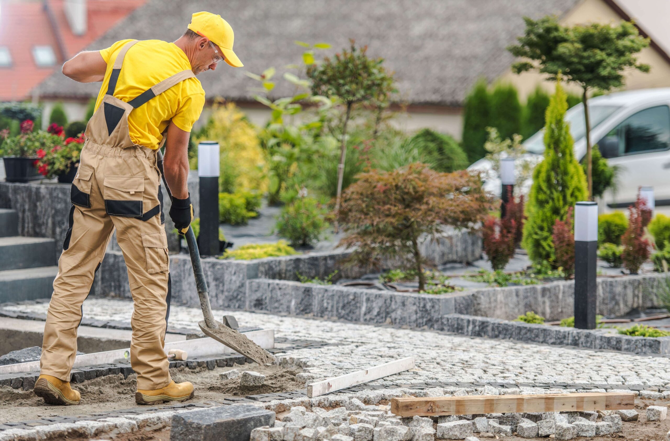 Landscaper using a shovel to install hardscaping features into a yard