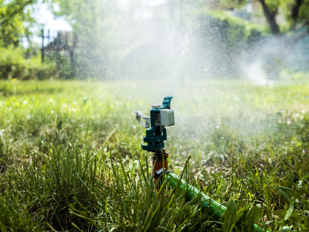 Newly repaired residential sprinkler system spraying water